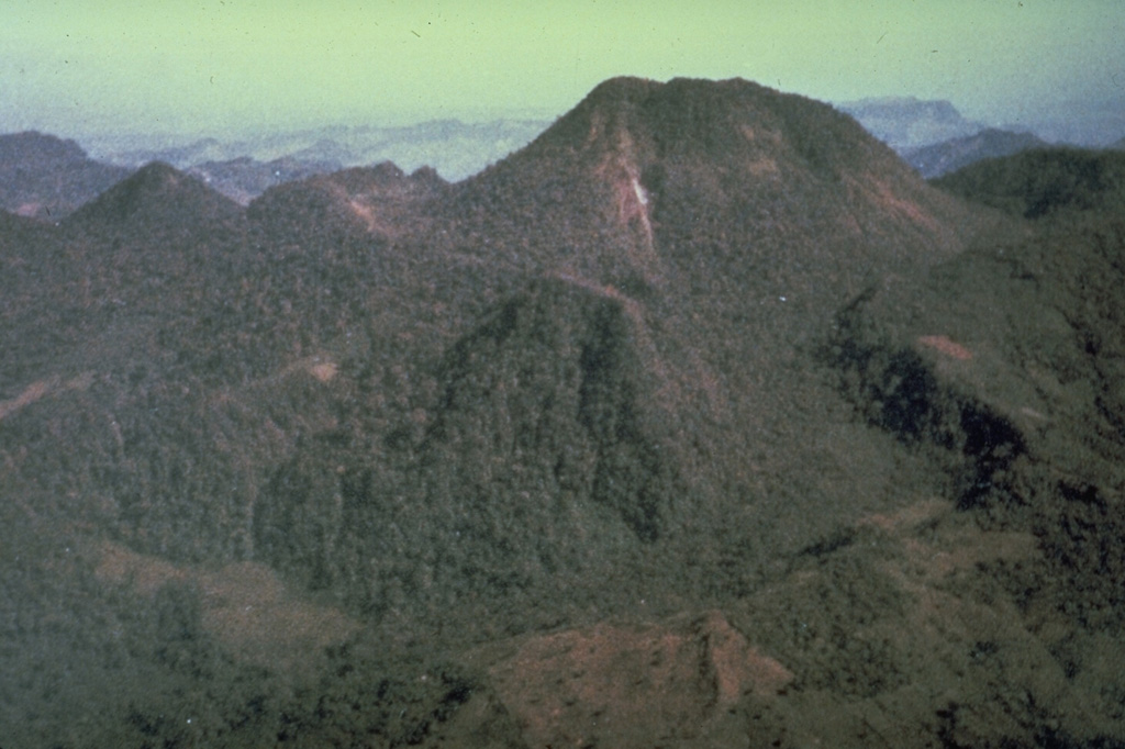 Prior to the major 1982 eruption, El Chichón contained a large summit lava dome (upper right) and a lower flank dome (center) inside two overlapping craters, seen here from the SW in 1981. A small steam plume rises from a fumarole along a fault down the left side of the larger dome. The last major eruption of El Chichón prior to 1982 occurred about 500 years ago, but residents reported an eruption about 130 years ago that was witnessed by their grandparents but was not strong enough to prompt an evacuation. Photo by René Canul, 1981 (Comisión Federal de Electricidad).