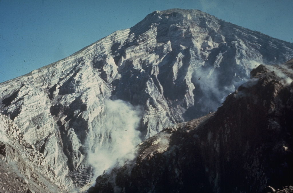 The interior of a stratovolcano is dramatically revealed in a 1-km-wide crater created on the SW flank of Guatemala's Santa María volcano during an eruption in 1902. The 1,200-m-high scarp exposes thin, light-colored lava flows that are interbedded with deposits of fragmented rock produced during growth of the volcano. The 1902 eruption was one of the world's largest during the 20th century. Photo by Dick Stoiber, 1969 (Dartmouth College).