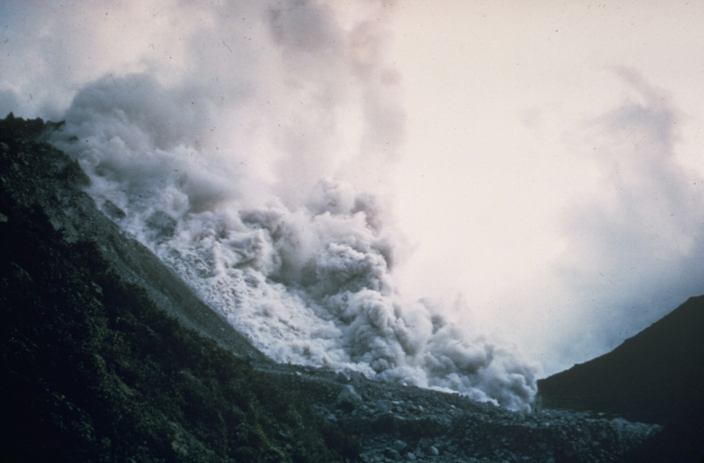 A pyroclastic flow produced by collapse of a growing lava dome descends the northern flank of the Santiaguito lava dome in November 1967. Periodic larger collapses of Santiaguito have sent pyroclastic flows down the populated southern flanks. The most catastrophic of these traveled 10 km in 1929, when hundreds to thousands of people were killed.  Photo by Dick Stoiber, 1967 (Dartmouth College).
