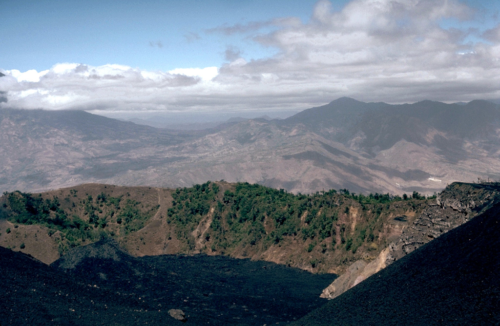 Cerro Chino produced a major eruption in 1775. This eruption began at vents on the SW flank (behind the crater in this view) and then migrated towards the summit. Powerful lava fountains were observed and ashfall was reported up to 200 km away. Recent lava flows are in the foreground. Photo by Lee Siebert, 1988 (Smithsonian Institution).