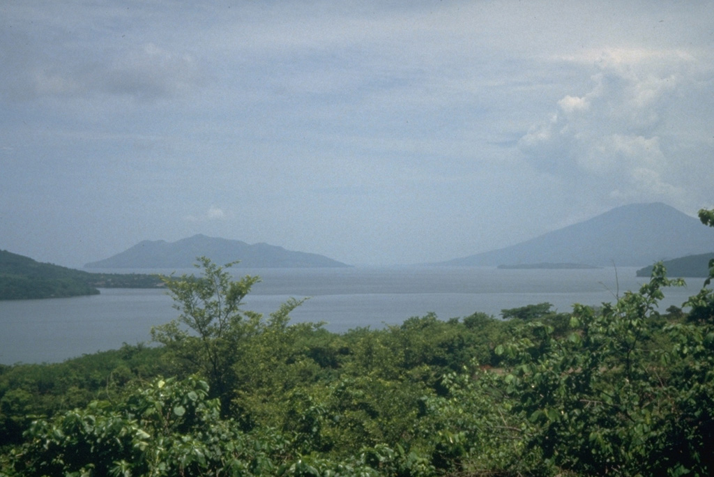Conchagüita (left), an island in the Gulf of Fonseca, and Conchagua (right) a volcano on the Salvadoran mainland are seen here across the Gulf of Fonseca from the NE on the island of Zacate Grande in Honduras.  Both Conchagüita and Conchagua are extensively eroded, but a historical eruption was reported from Conchagüita.  The NW flank of Isla El Tigre volcano forms the ridge extending into the sea at the extreme left. Photo by Mike Carr, 1991 (Rutgers University).