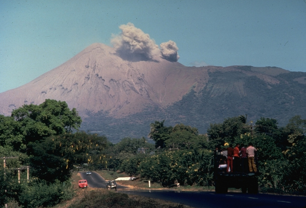 A small ash cloud from an eruption in 1977 rises from the crater of Telica volcano as seen from the outskirts of the city of León.  Intermittent explosions began in November 1976, and continued at a rate of one sizeable explosion a month until November 1977, when activity increased.  On November 11 ashfall reached the Pacific Ocean.  The eruption continued into January 1978. Photo by Jaime Incer, 1977.