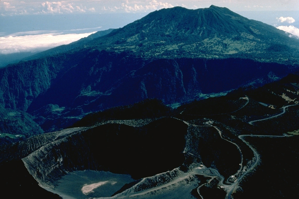 The foreground crater in this aerial photo from the SW is the principal summit crater of 3432-m-high Irazú volcano.  The massive stratovolcano in the background is 3340-m-high Turrialba volcano.  Roads of widely divergent quality lead to the summit craters of both these historically active volcanoes, the two highest in Costa Rica. Copyrighted photo by Katia and Maurice Krafft, 1983.