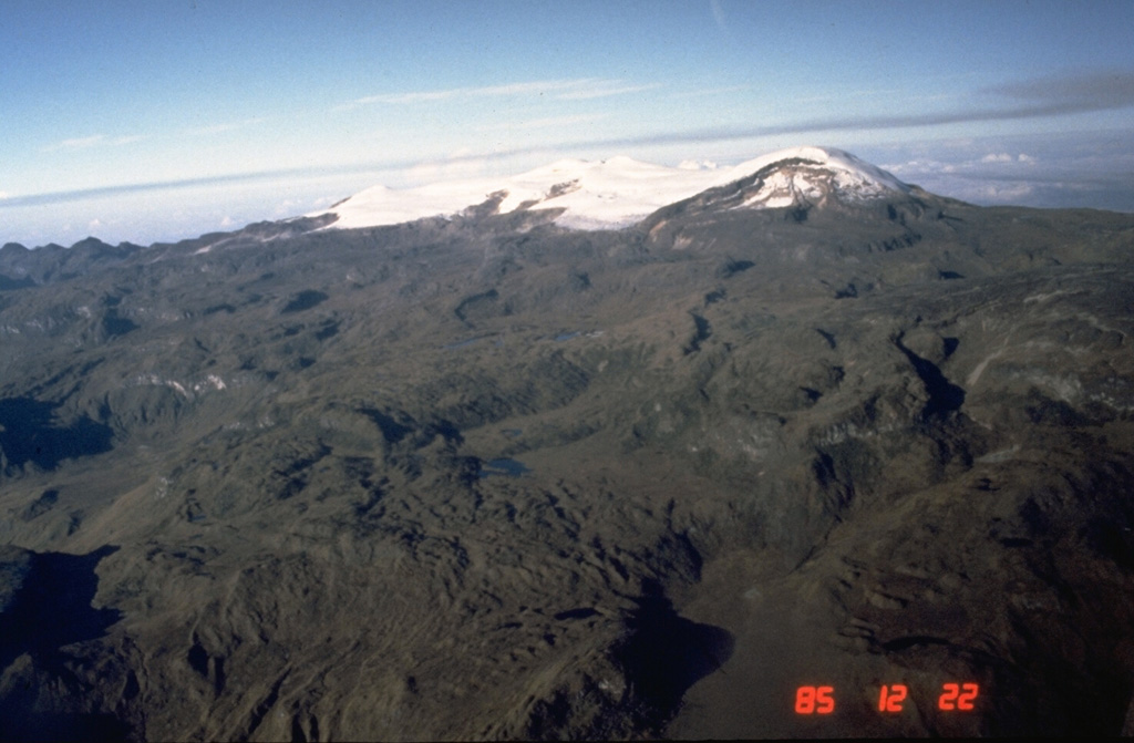 Santa Isabel is a small glaciated volcano is seen here from its much larger neighbor to the NE, Nevado del Ruiz. Holocene lava flows fill SW and SE valleys. A small Holocene lava dome was emplaced about 10 km SW of the volcano. Photo by Norm Banks, 1985 (U.S. Geological Survey).