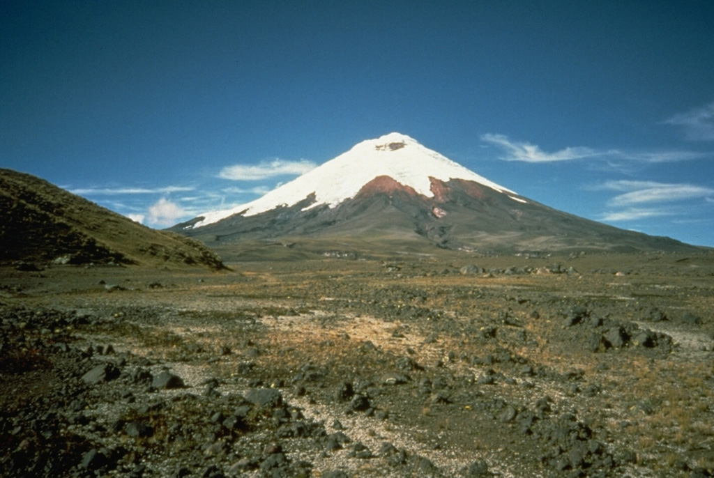 The foreground of this flat valley north of Cotopaxi volcano is the top of the deposit produced by a massive lahar from the volcano in 1877.  During this eruption, one of the largest from Cotopaxi during historical time, pyroclastic flows descended all sides of the volcano, creating devastating lahars.  The lahar that produced this deposit eventually traveled north down the Guayllabamba River past Quito to reach the Pacific Ocean at Esmeraldas, 225 km NW of Cotopaxi.  Mudflows also swept down valleys south and east into the western Amazon basin. Photo by John Ewert, 1987 (U.S. Geological Survey).