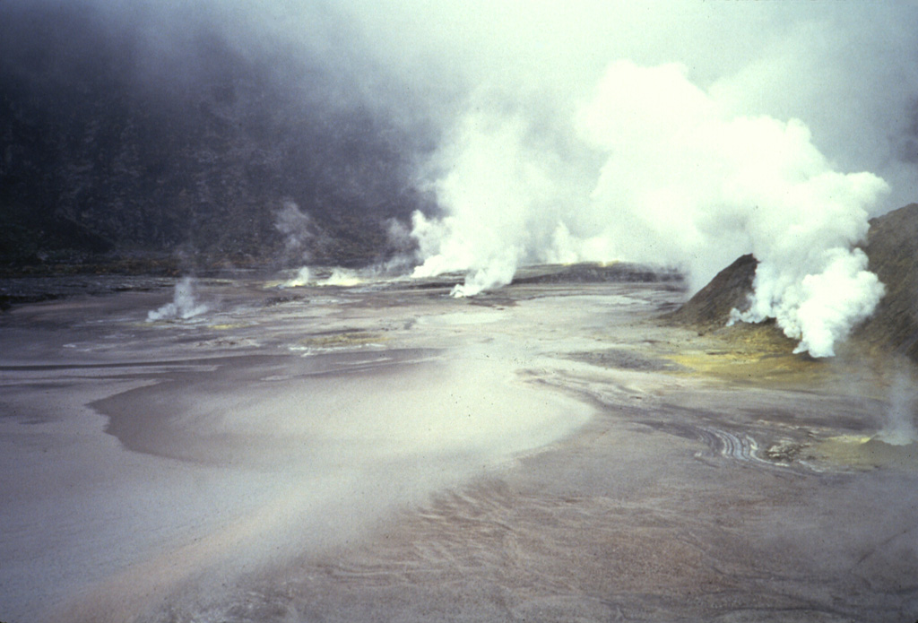 A dense plume emanates from fumaroles occupying the floor of Kaba Lama, the largest of the three major summit craters of Kaba volcano. A shallow lake occupying the crater floor is one of several in the Kaba crater complex. Anonymous, 1991.
