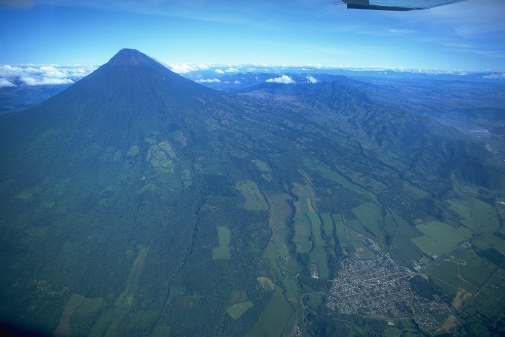 Volcán de Agua is seen here in an aerial view from the SE, with the town of Palín to the lower right along the highway between Guatemala City (just out of view to the right) and Escuintla.  Copyrighted photo by Stephen O'Meara, 1994.