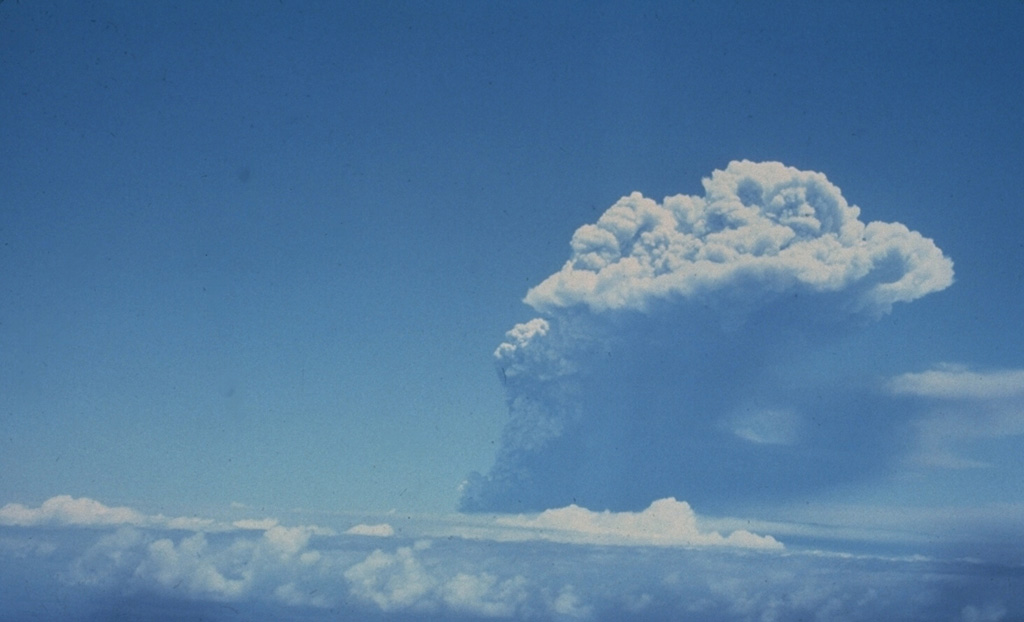 An eruption column at the right rises above atmospheric clouds on the afternoon of April 13, the first day of the 1979 eruption of Soufrière St. Vincent volcano.  The ash column reached a height of 10 km.  Several explosions took place on the 13th, two on the 14th, and single explosions occurred on the 17th, 22nd, and 25th.  A pyroclastic flow on the 14th descended the west flank and traveled at least 10 km out to sea. Photo by John Shepherd, 1979 (University of West Indies).