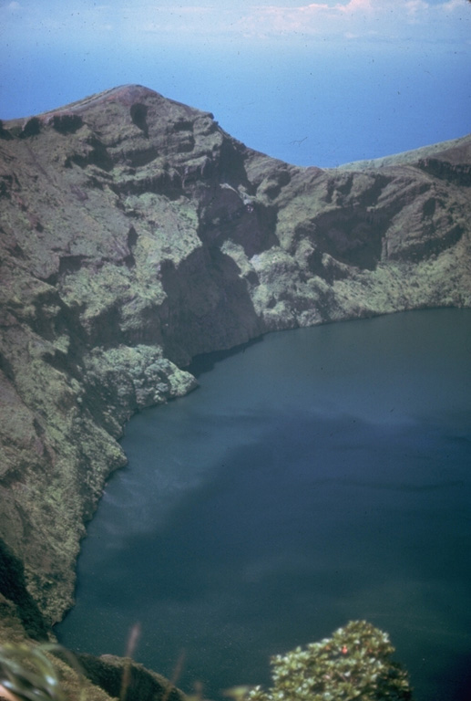 Prior to an eruption in 1971, the summit crater of Soufrière volcano was filled with a crater lake with a maximum depth of 180 m.  Its floor was 560 m below the north crater rim.  In 1971 a lava dome slowly and almost aseismically began growing on the crater floor.  It first breached the surface on November 3 and eventually formed a large island that left only a narrow moat of lake water. Photo by Jack Frost.