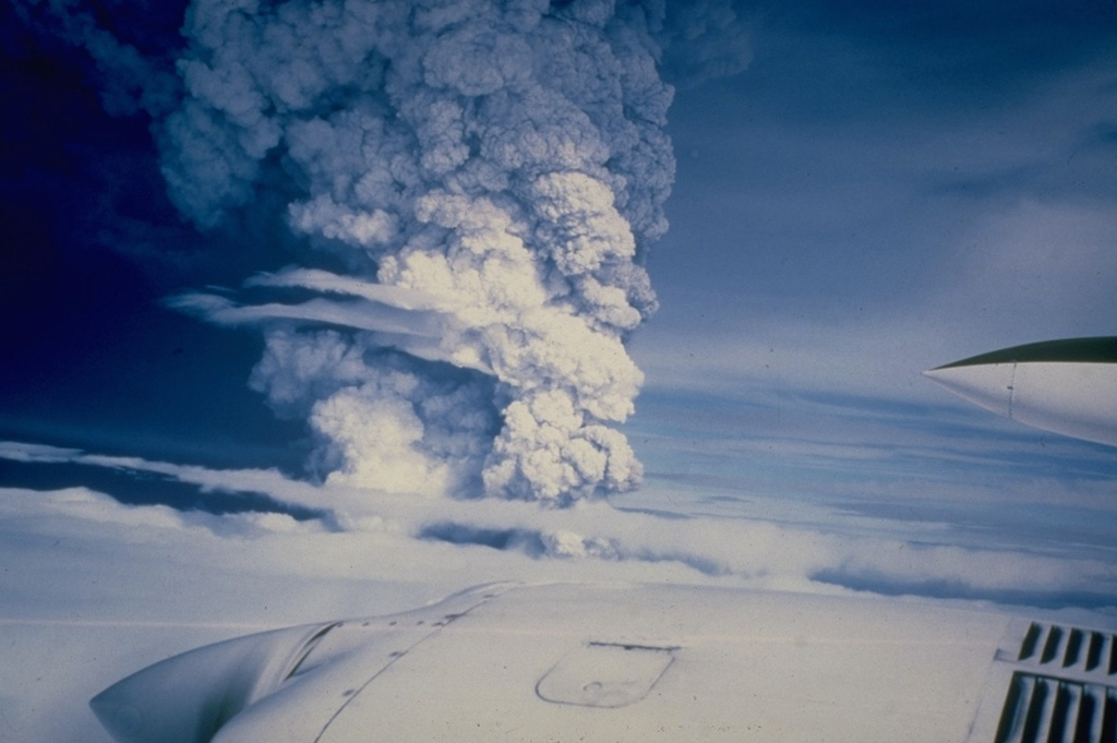 An eruption column is seen rising above a cloud layer over Hekla volcano on 17 August 1980. The eruption began with a Plinian phase producing this 15-km-high eruption column. Lava flows were simultaneously produced along the fissure that runs along the Hekla edifice. During the next three days, lava flows issued from nearly the full length of the fissure and produced six flows, primarily on the northern side of the summit ridge. One lava flow travelled about 8 km to the SW. Photo courtesy of Gudmundar Sigvaldason (Nordic Volcanological Institute), 1980.
