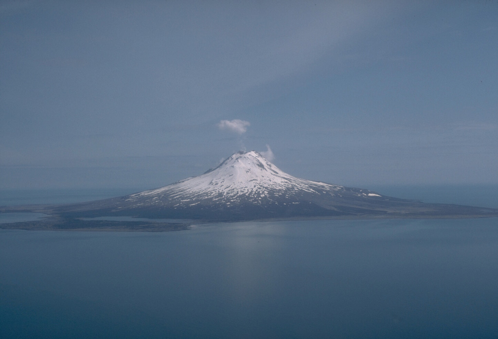 Augustine forms an 8 x 12 km island in Kamishak Bay, within the southern Cook Inlet. The cone is a complex of overlapping summit lava domes. An apron of pyroclastic debris, consisting mostly of large debris avalanche deposits produced by collapse of portions of the summit lava domes, extends to the sea on all sides. West Island, at front left in this 1989 view from the west, is a debris avalanche deposit that was emplaced roughly 250-450 years ago. Photo by Tom Miller, 1989 (Alaska Volcano Observatory, U.S. Geological Survey).