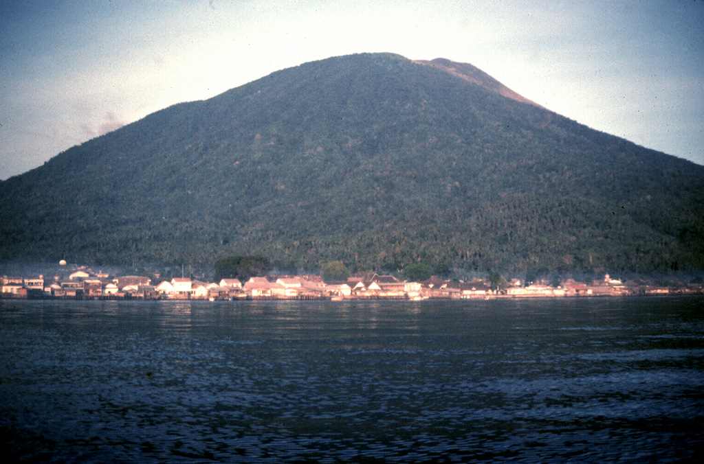 Gamalama (Peak of Ternate) is a near-conical stratovolcano that rises abruptly NW of the city of Ternate, the principal port of the renowned spice islands of northern Maluku.  Three cones, progressively younger to the north, form the summit of Gamalama.  Several maars and vents define a rift zone, parallel to the Halmahera island arc, that cuts the volcano.  Eruptions from Gamalama, one of the most active volcanoes in Indonesia, have been recorded since the 16th century.    Photo by Jack Lockwood, 1980 (U.S. Geological Survey).