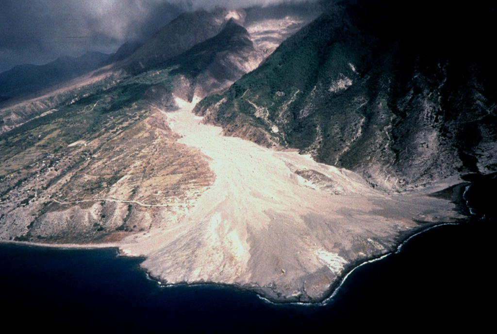 The second of two large deltas formed by the accumulation of pyroclastic-flow deposits is located at the mouth of the White River valley on the southern flank of Soufrière Hills volcano.  The pyroclastic flows spilled over a notch on Galway's wall on the southern rim of the summit crater and traveled down the White River, diverging around the flank of the older South Soufriere Hills volcano (right).  The accumulated pyroclastic-flow deposits buried Galway's Soufrière, a thermal area on the upper flank, and the evacuated town of O'Garra's on the coast. Photo by Peter Francis, 1997 (Open University).