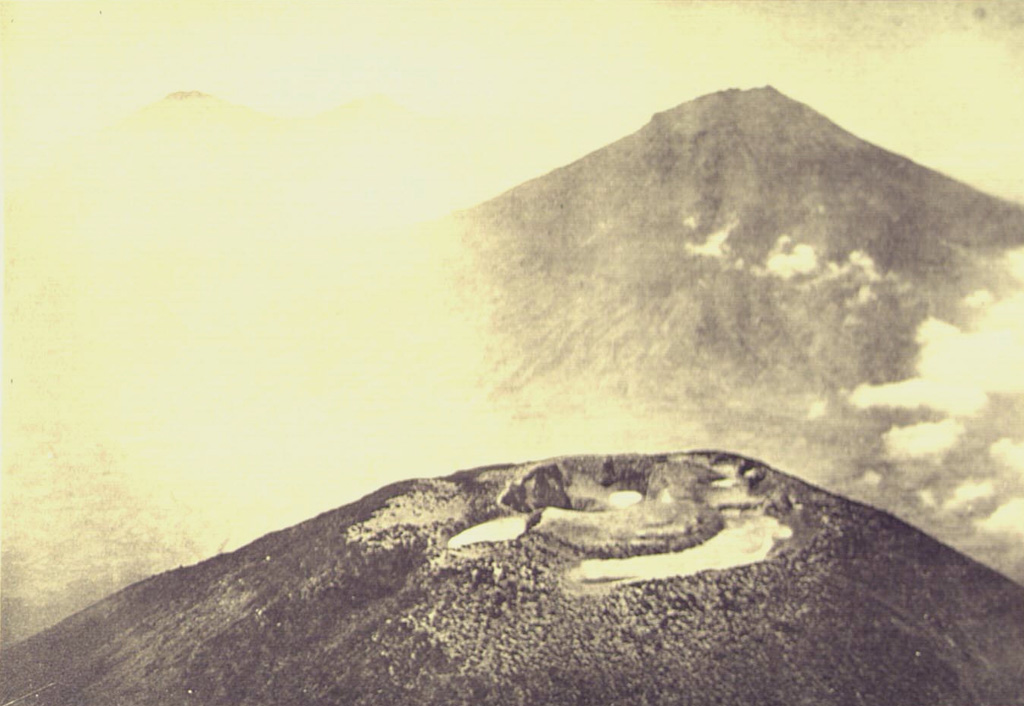 An aerial view from the NW looks across the summit crater complex of Gunung Sundoro volcano towards Gunung Sumbing. These roughly 3,000-m-high volcanoes form prominent landmarks between the Dieng volcanic complex and the city of Yogyakarta. Both volcanoes have erupted in historical time. Photo published in Taverne, 1926 