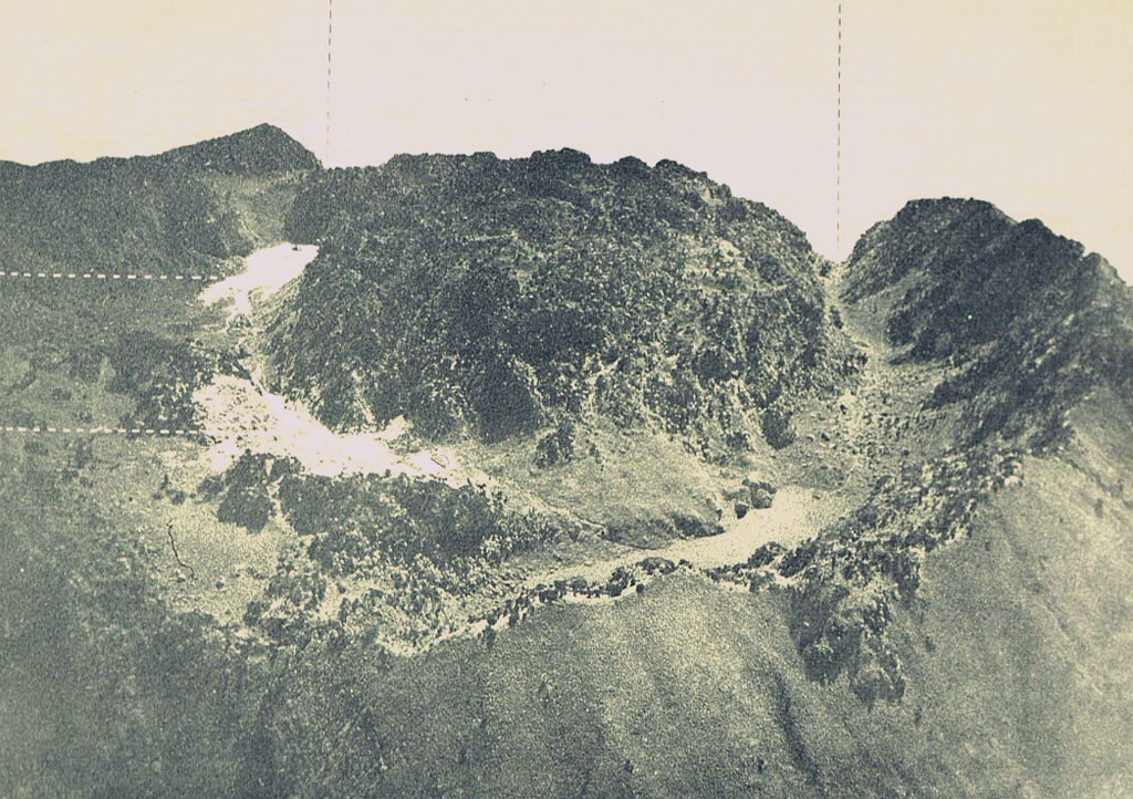 A lava dome fills the summit crater of Gunung Sumbing. This view from the south shows the breached NE crater rim. The upper light-colored area on the left is a small pond, and the lower is a fumarolic area. Photo published in Taverne, 1926 