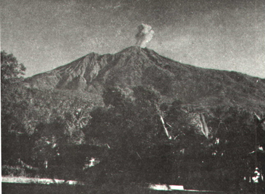 An eruption plume above the summit of Karengetang (Api Siau) volcano is seen from Ulu village on the northern flank sometime during 1961.  Explosive eruptions in that year began on February 28 and lasted until April.  Incandescent material was ejected to 300 m above the vent and the eruption plume rose 1.5 km above the crater.  Explosive activity also occurred in October 1961. Photo by M. Pantauw, 1961 (published in Kusumadinata 1979, 