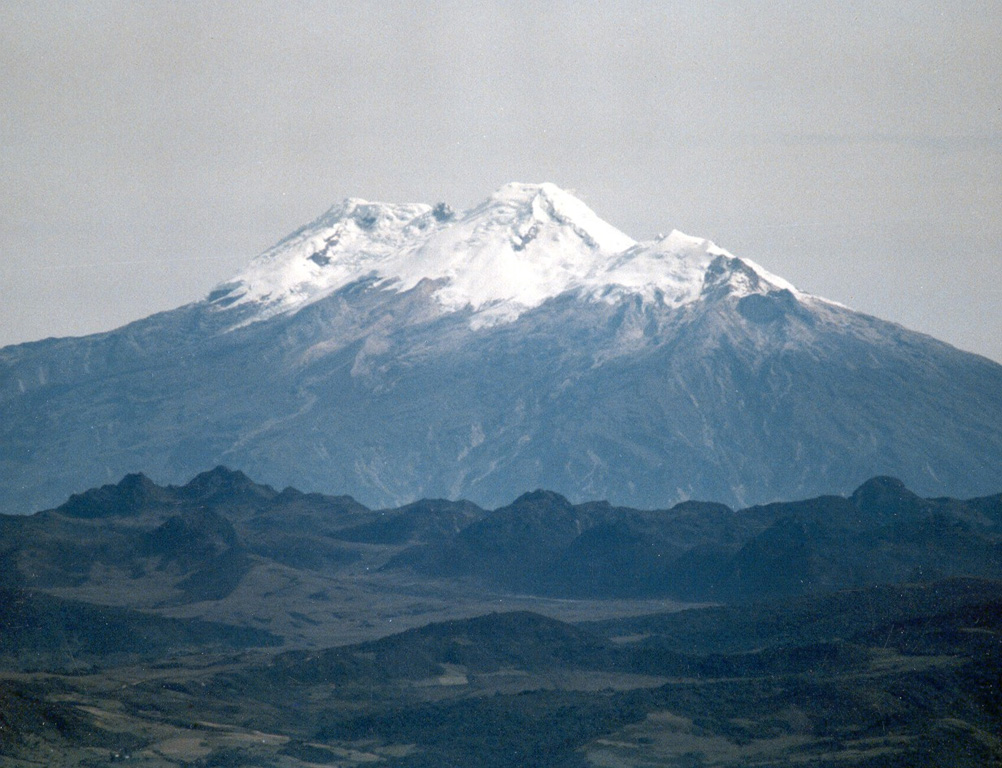 Nevado del Huila is an elongate, N-S-trending glaciated edifice constructed within an old caldera, seen here from the SW. The northern peak (La Cuesta) is to the left and the lower southern peak to the right is Pico Central. Photo by Juan Carlos Diago, 1995 (courtesy of Bernardo Pulgarín, INGEOMINAS, Colombia).