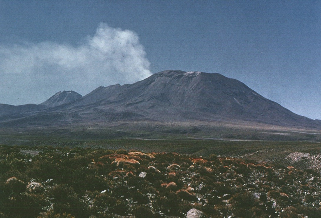 A strong plume of steam and sulfurous gases rises above the crater of Láscar volcano prior to the 1986 eruption.  Thermal anomalies detected on Thematic Mapper satellite images between December 1984 and July 1985 may have originated from a lava lake or lava dome in the summit crater, although there were no direct observations prior to the 1986 eruption.  Aguas Calientes volcano appears on the left horizon in this view from the NW.     Photo by Oscar González-Ferrán (University of Chile).