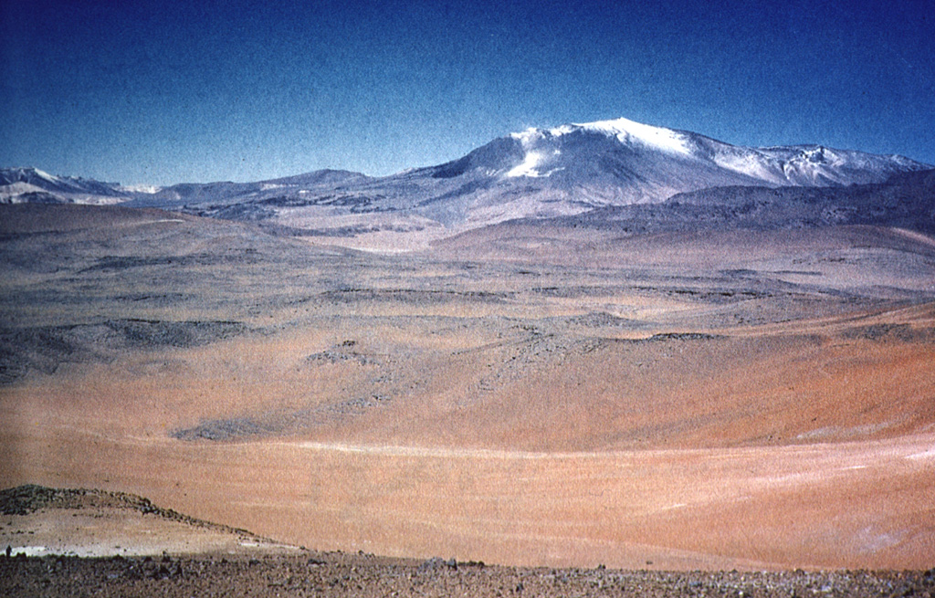 The elongated NNW-trending edifice of 5697-m-high Lastarria volcano rises above pyroclastic-flow deposits that form an extensive apron below the northern flanks of the volcano.  Five nested craters are found along a semi-arcuate line on the summit ridge.  The youngest feature is a lava dome that overlaps the northern crater rim.  Persistent fumarolic activity occurs at the summit and NW flank, and small sulfur flows 350 m long have been produced by melting of extensive sulfur deposits in the summit region. Photo by Paula Cornejo, courtesy of Oscar González-Ferrán (University of Chile).