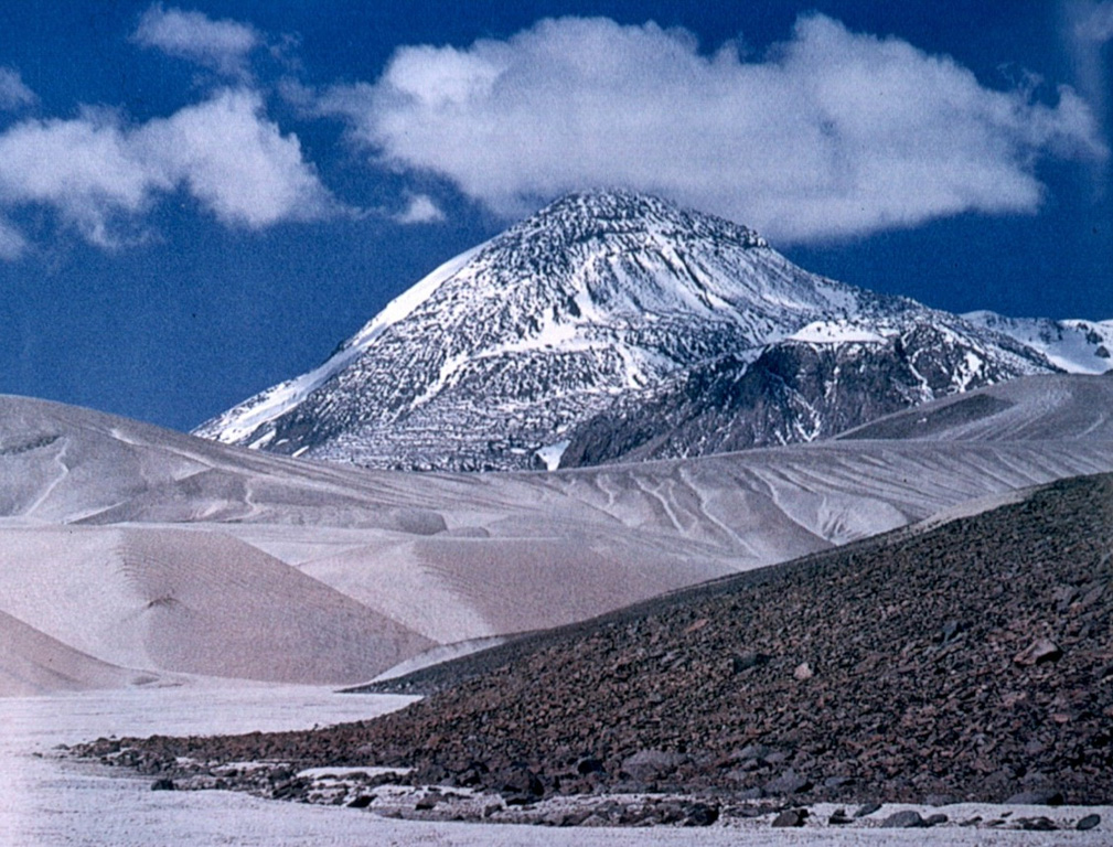 The dacitic volcanic complex of El Muerto abuts Nevados Ojos del Salado volcano on the east and NE.  The summit of this massive complex contains dacitic lava domes and is cut by a 2.5-km-long depression containing a dozen eruptive centers; an additional two dozen centers lie outside the depression.  Lava flows from these centers cover an area of 120 km2.  The summit lava domes are of Pleistocene age, but the complex is cut by ENE-trending fractures that formed during Holocene eruptions of Ojos del Salado. Photo by Oscar González-Ferrán (University of Chile).