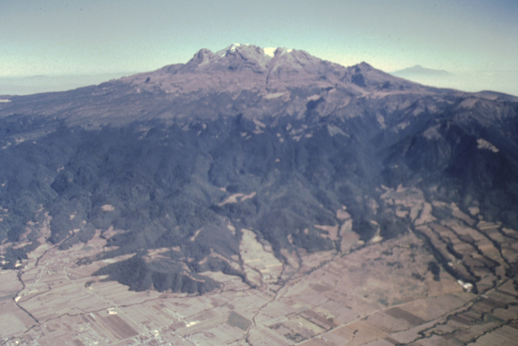 Iztaccíhuatl rises more than 2.5 km from the floor of the Valley of Mexico to form one of Mexico’s highest volcanoes. The profile of a sleeping woman in the legend of Popocatépetl and Iztaccíhuatl can be seen in this view from the west. The massive 450 km3 volcano is a composite of overlapping edifices along a N-S-trending line. Photo by José Macías, 1995 (Universidad Nacional Autónoma de México).
