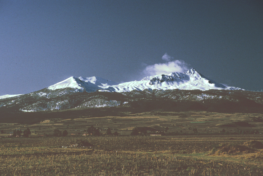 Nevado de Toluca is seen here from the NW just after a winter snowfall. The Pico del Fraile summit is to the right. Late-Pleistocene block-and-ash flows and Plinian eruptions have affected all sides of the volcano. Photo by Paul Wallace, 1992 (University of California Berkeley).