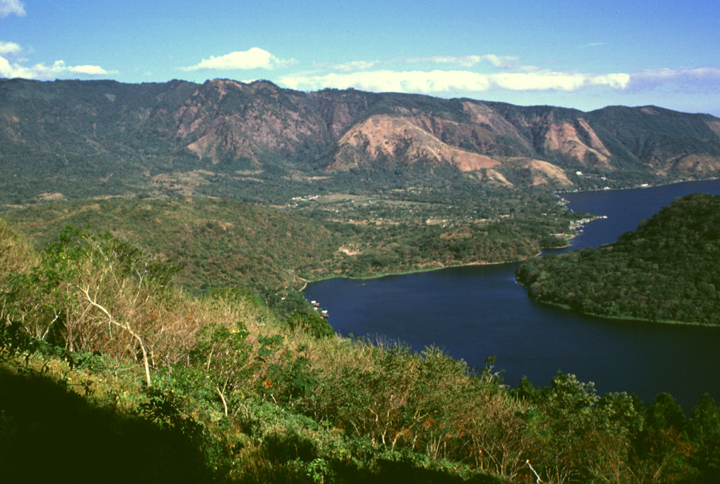The SW part of Coatepeque caldera was formed about 57,000 years ago following the eruption of the roughly 16 km3 Congo biotite-bearing rhyolitic pumice fall and pyroclastic flow deposits. Plinian and phreatoplinian eruptions took place through a lake that formed in the NE part of the caldera that formed during the larger Arce eruption about 72,000 years ago. Photo by Lee Siebert, 1999 (Smithsonian Institution).