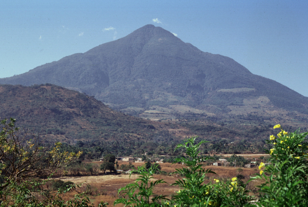 The easternmost peak of San Vicente is seen here from the NE along the road to the city of San Vicente. The hill in the foreground (left) is Cerro Ramírez, a flank cone that is one of the most recent features of the volcanic complex.  Photo by Paul Kimberly, 1999 (Smithsonian Institution).