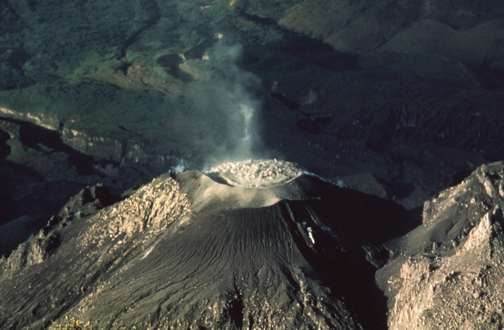 A lava dome fills the crater of the Caliente vent of a Santiaguito lava dome in 1988, as seen from the summit of Santa María. Slow dome growth was accompanied by periodic explosions that ejected ash plumes to about 1.5 km above the vent. Photo by Jon Fink, Arizona State University, 1988 (courtesy of Bill Rose, Michigan Technological University).