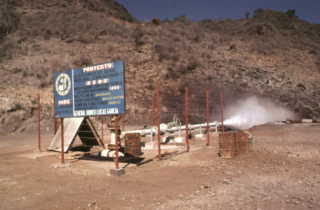 The Almolonga volcano Zunil geothermal project is seen here in 1981, a decade prior to a landslide that buried the well site. Well ZCQ-4 was drilled in 1981 to a depth of about 1.3 km and cemented to a depth of 400 m. In October 1989 the recorded bottom hole temperature was 260°C. The upper part of the geothermal system contains acid-sulfate hot springs. Associated mud pools and fumaroles occur at high points on both sides of the Río Samalá, and bicarbonate-rich hot springs discharge into the river's canyon. Photo by Bill Rose, 1981 (Michigan Technological University).