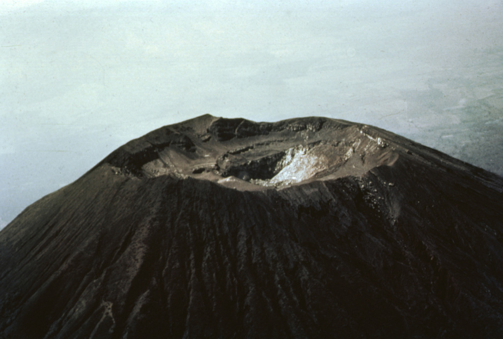 The summit of San Miguel volcano was reported to be peaked prior to the 16th century, but now is truncated by a 1-km-wide crater.  This aerial view shows the 2130 m high point on the far NE crater rim in the center of the photo and several benches cut by a roughly 250-m-deep central crater.  The morphology of the crater has varied greatly during historical time as a result of the creation and subsequent destruction of new craters.  A cinder cone that formed in the NE part of the crater in 1884 had disappeared 50 years later.   Photo by Willard Parsons, 1964 (courtesy of Bill Rose, Michigan Technological University).