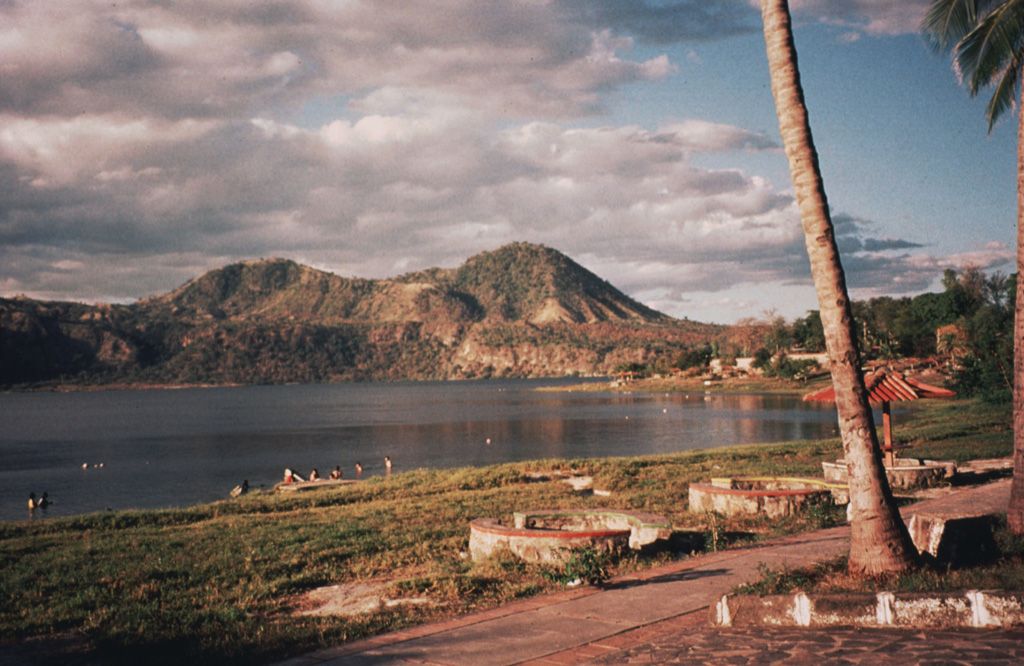 The SE shore of Laguna de Jiloa is the site of tourist resorts that are popular destinations from the nearby capital city of  Managua.  The Chiltepe Hills on the horizon beyond the caldera rim to the north are the high points of the Chiltepe Peninsula. Photo by Jaime Incer, 1996.