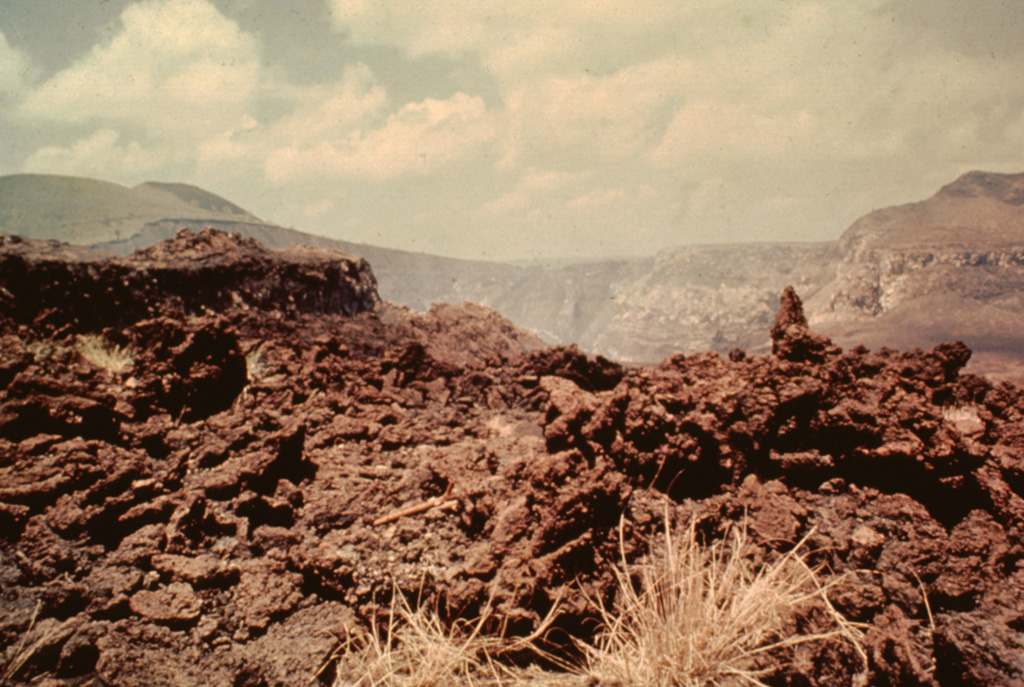 The 1670 lava flow from Nindirí crater in the background is seen here spilling over the crater rim.  A series of lava lakes emplaced in 1670 eventually overflowed the rim through this narrow notch and produced a large lava flow that traveled 5 km down the north flank of the intracaldera cone. Photo by Jaime Incer, 1977.