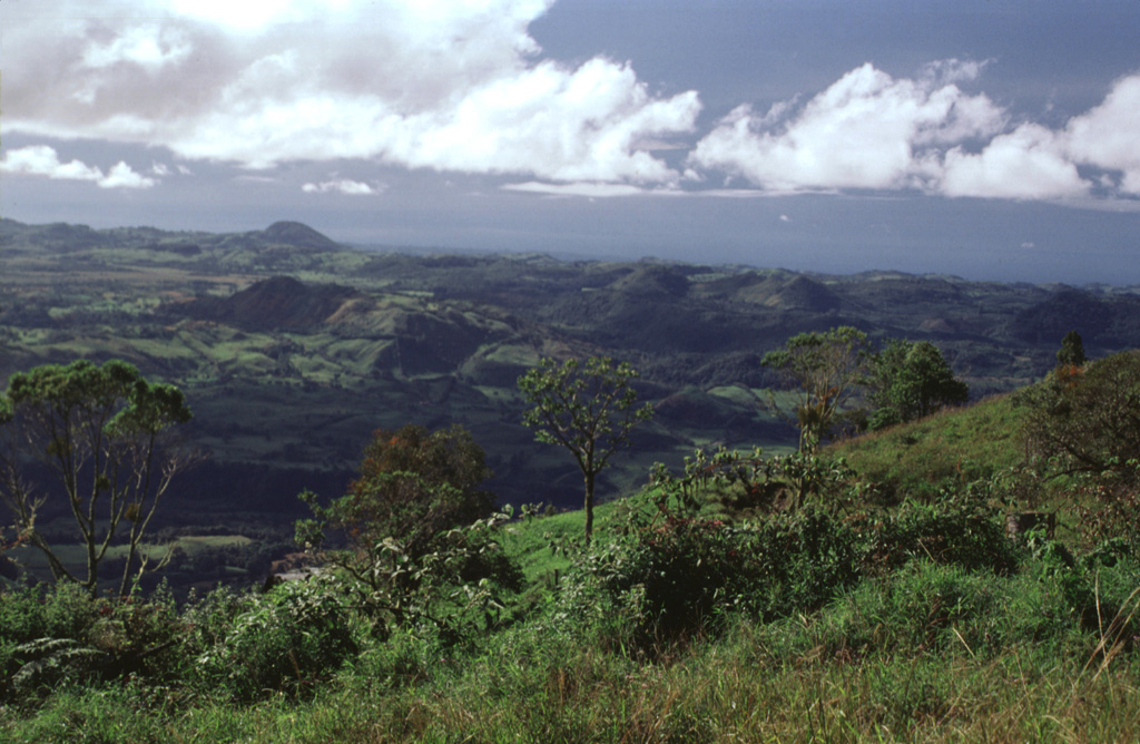 The irregular hummocky terrain extending to the south toward the Pacific coastal plain is part of a massive debris avalanche deposit that originated from flank collapse of Volcán Barú. This view is from Cerro Pando, a lava dome to the west. At least two flank failure events have occurred, producing voluminous debris avalanche deposits that form a broad deposit reaching beyond the Pan-American highway to the Pacific coastal plain. Photo by Lee Siebert, 1998 (Smithsonian Institution).