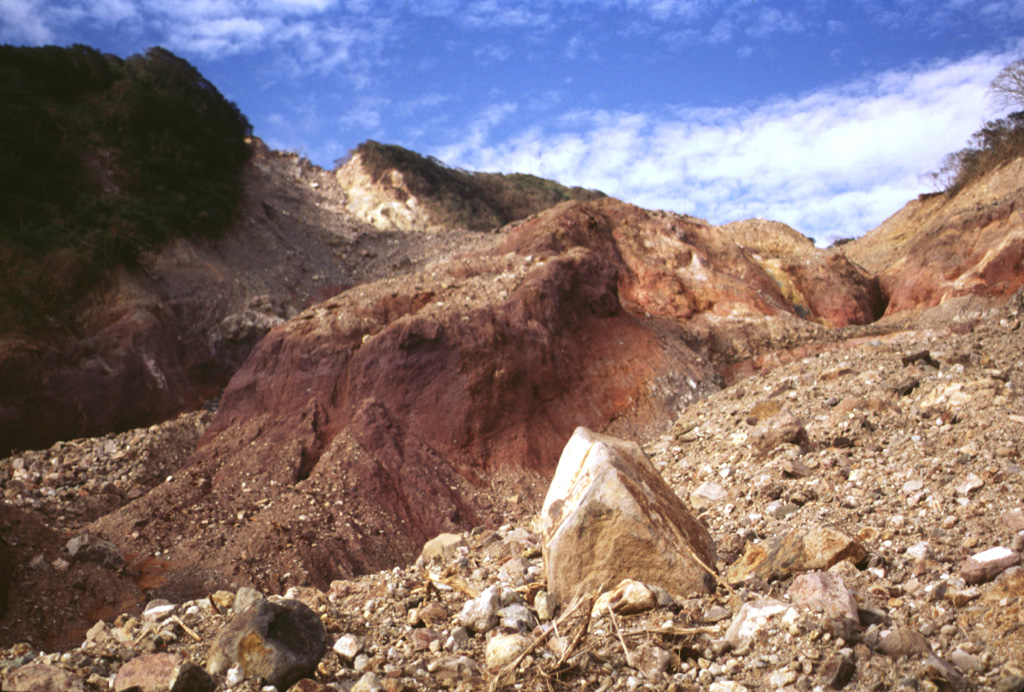 The devastating mudflow of October 30, 1998 originated from a small debris avalanche produced when part of the summit ridge of Casita volcano collapsed during torrential rains accompanying Hurricane Mitch.  The source scarp, no more than a few hundred meters in length and a few tens of meters deep, is the light-colored area on the horizon at the upper left.  The proximal part of the avalanche, deposits of which are seen in the right foreground, scoured into deeply hydrothermally altered rocks in the middle of the photo. Photo by Lee Siebert, 1998 (Smithsonian Institution).