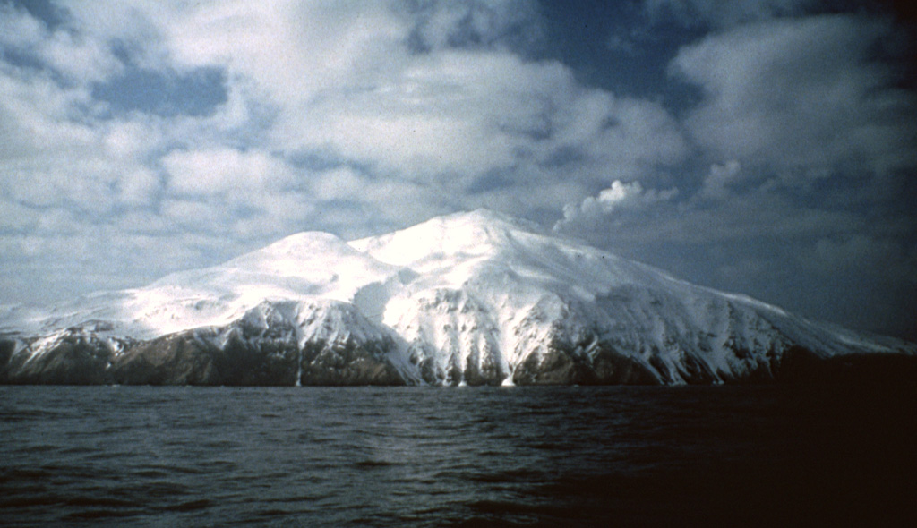 A steam plume rises from the summit of Kiska, one of the westernmost historically active volcanoes of the Aleutian Arc. Three sides of the volcano, including the northern side seen here, are bounded by steep cliffs up to 450 m high. A scoria cone on the flank formed in 1962 at the northern coast. Photo by E.V. Kleff, 1985 (U.S. Fish & Wildlife Service, courtesy of Alaska Volcano Observatory).