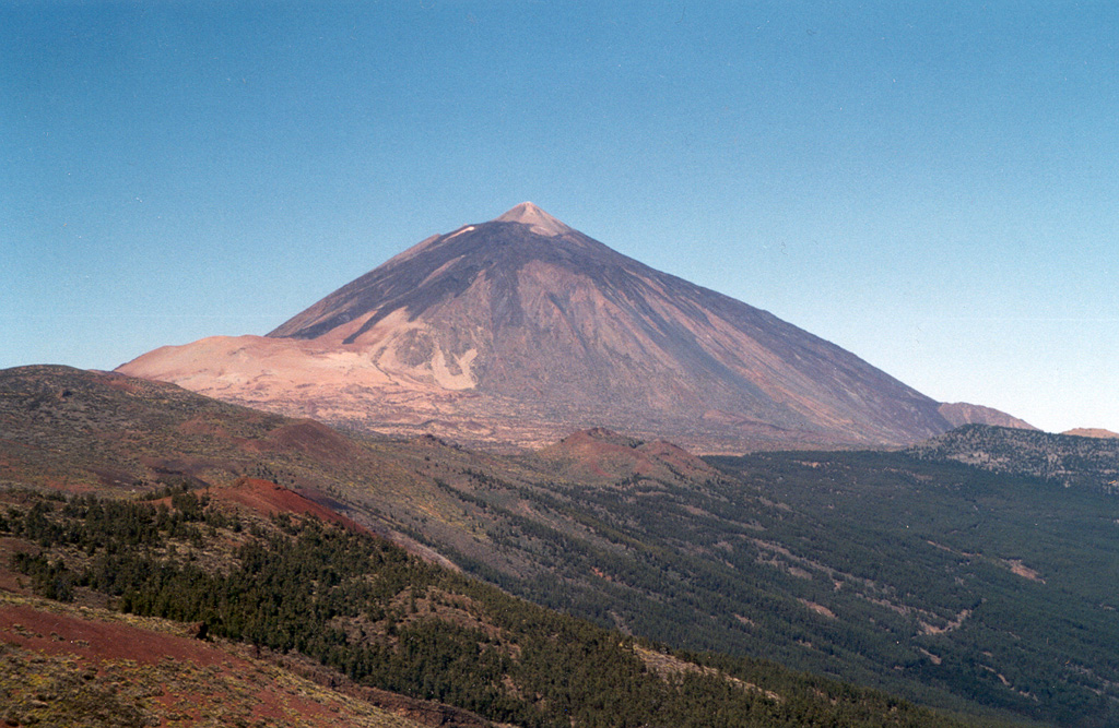Teide volcano, the highest point on the island of Tenerife, towers above the scarp of the massive Orotava landslide, which occurred about 600,000 years ago. The light-colored area on the eastern foot of the volcano (left) is covered by tephra deposits from the Plinian Montana Blanca eruption about 2,000 years ago. Teide was constructed within the 10 x 16 km wide Las Cañadas caldera on the SW side of Tenerife. The large triangular island is composed of a complex of overlapping stratovolcanoes that have remained active into historical time. Photo by Alexander Belousov, 2001 (Institute of Volcanology, Kamchatka, Russia).