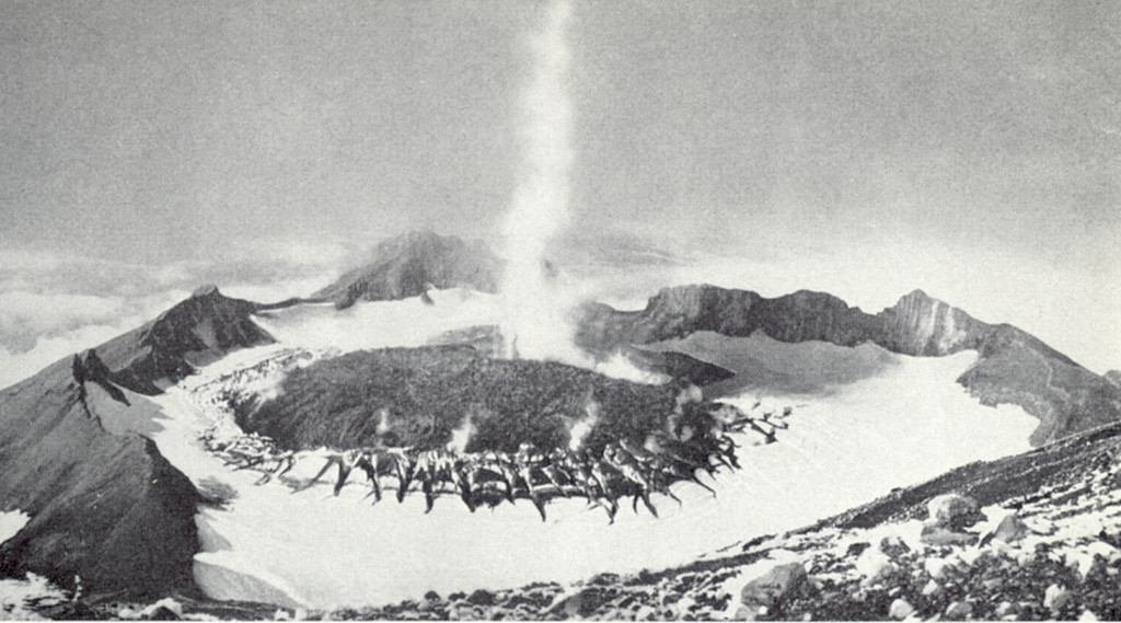 This September 1946 photo of Great Sitkin from the E rim of the summit crater shows a plume rising above a lava dome emplaced in the crater in March 1945. The fissures in the ice were produced as the dome grew through the summit glacier. Photo courtesy of U.S. Geological Survey (published in USGS Bulletin 1028-B).