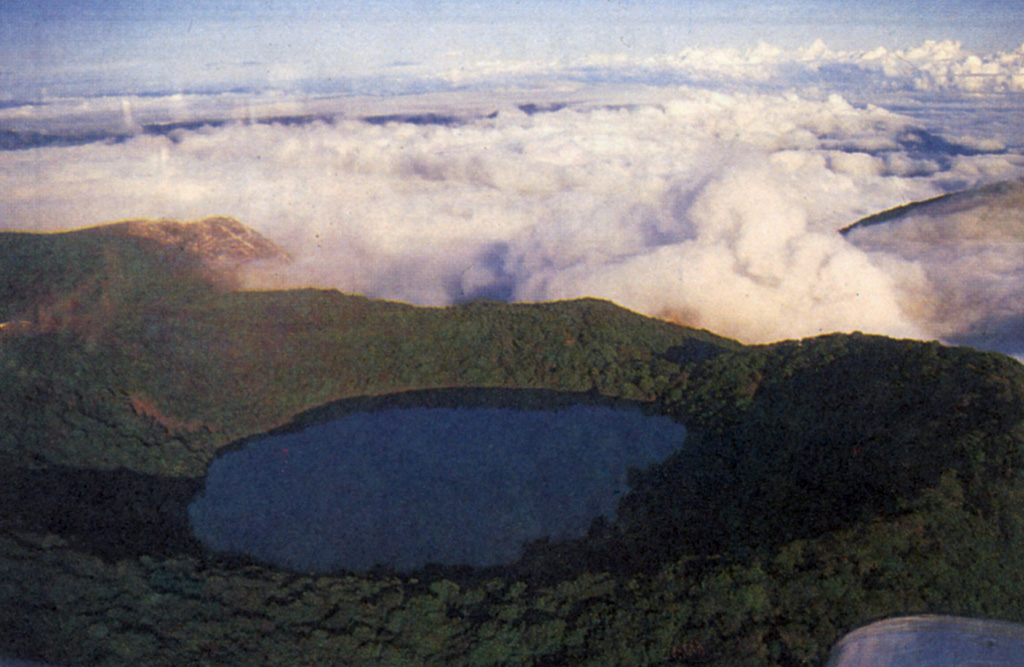 Botos cone forms the high point of the Poás volcanic massif. It was the eruptive focus prior to about 7,500 years ago, when activity shifted NW to the crater hidden beneath the clouds. The 1-km-wide crater contains a 400-m-wide lake. Photo by S. Mora, 1988 (courtesy of Guillermo Alvarado, Instituto Costarricense de Electricidad).
