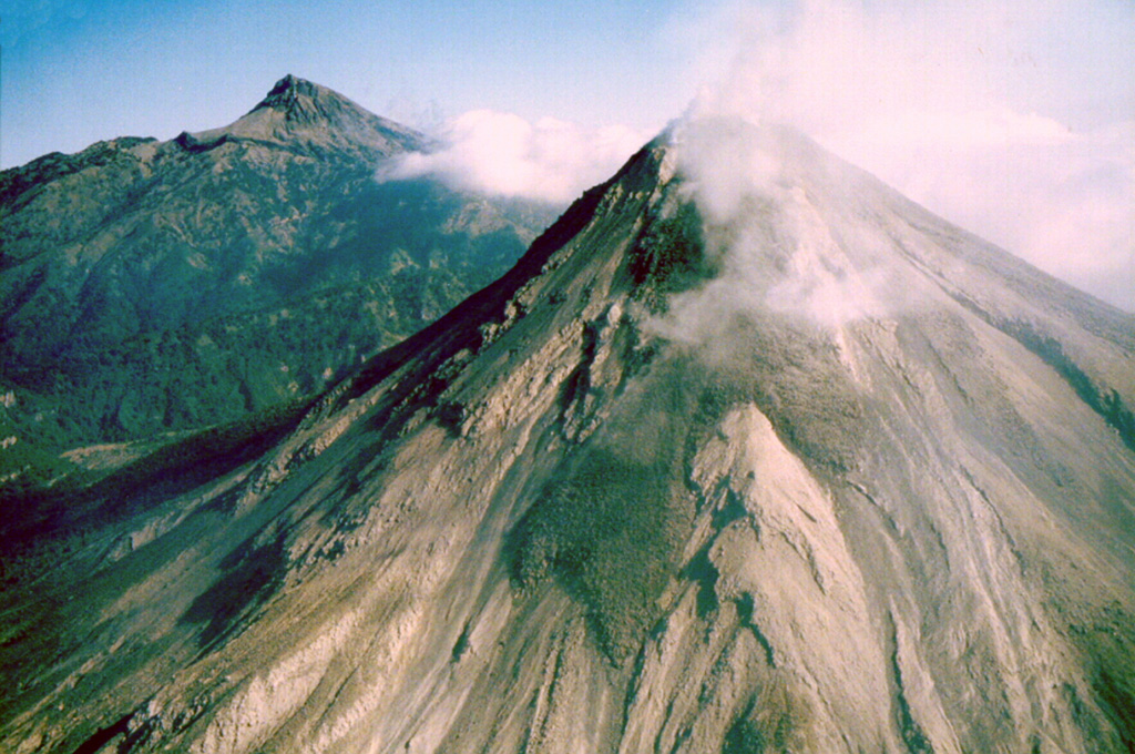An overflight on the morning of 3 December 1998 shows lava flows advancing down the SW flank of Colima. The flow in the center is diverted by a topographic high into two lobes. By the previous day the three lava flows on the SSW flanks had reached estimated lengths of 1 km (westerly flow), 1.2 km (central flow), and 0.9 km (SE flow). Nevado de Colima is to the left. Photo by Juan Carlos Gavilanes, 1998 (Colima Volcano Observatory, Universidad de Colima).