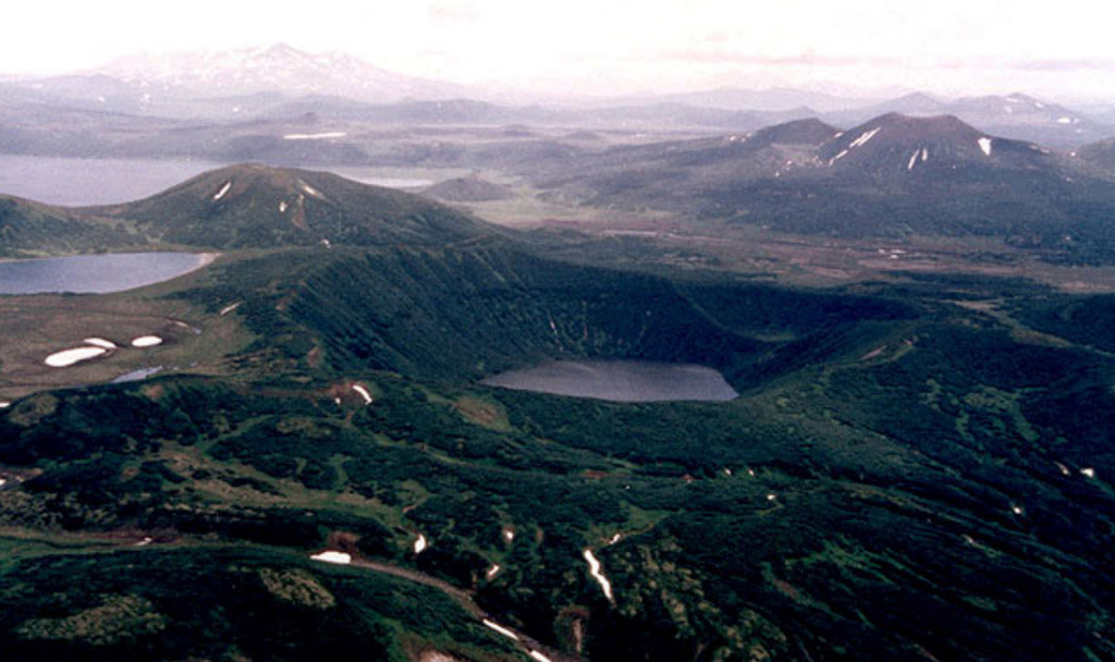 Chasha crater contains the lake in the middle of this photo. It formed about 4,600 years ago and produced about 1 km3 of rhyolitic tephra (marker ash layer OPtr). It is located in the northern part of the Tolmachev Dol (Plateau) and is surrounded by Holocene basaltic scoria cones. The next lake to the left was dammed by the Chasha eruption products. The most distant water body to the left is Tolmacheva Lake; Tolmacheva river valley is between Chasha lake and distant cones at the right. Copyrighted photo by Philip Kyle (Holocene Kamchataka volcanoes; http://www.kscnet.ru/ivs/volcanoes/holocene/main/main.htm).