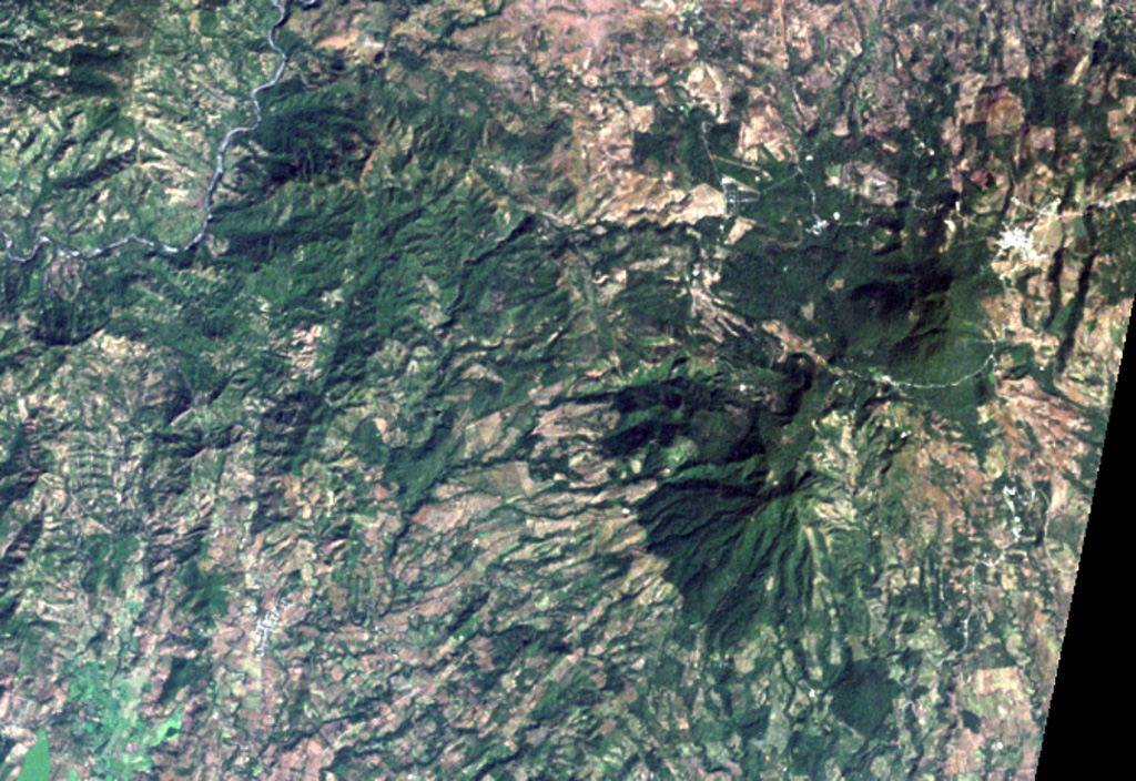 The large forested area at the middle right is the 1662-m-high Moyuta volcanic complex, its summit composed of a series of overlapping andesitic lava domes.  The small white-colored area above and to the right of the dome complex is the city of Moyuta, which lies at an altitude of nearly 1300 m.  Moyuta is the easternmost of the chain of large stratovolcanoes stretching across the Guatemalan Highlands. NASA Landsat image, 2000 (courtesy of Loren Siebert, University of Akron).