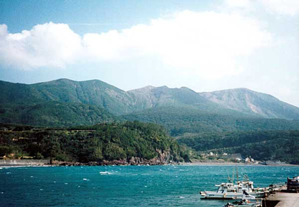 Kuchinoerabu rises to the SE above the fishing village of Motomura. The active cone of Shindake is in the center, Sankakutenyama is to the left, and Furudake (Hurudake) to the right. Shindake has been the site of frequent explosive eruptions in historical time. Several villages on the 4 x 12 km island are located within a few kilometers of the active crater and have suffered damage from eruptions. Copyrighted photo by Shingo Takeuchi (Japanese Quaternary Volcanoes database, RIODB, http://riodb02.ibase.aist.go.jp/strata/VOL_JP/EN/index.htm and Geol Surv Japan, AIST, http://www.gsj.jp/).