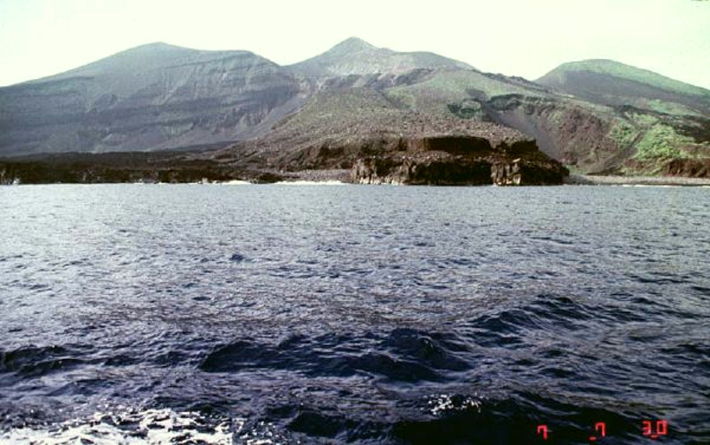 The dark-colored lava flow along the coast in the foreground was emplaced during an eruption that began on 17 August 1939. A new scoria cone (Iwoyama) was constructed in that year at the northern end of the 1902 crater. Two lava flows reached the sea, the first at Hyogowan (the bay to the far right) and the second at Chitose Bay. Two people were killed during the eruption, which ceased at the end of December. Copyrighted photo by Akira Takada (Japanese Quaternary Volcanoes database, RIODB, http://riodb02.ibase.aist.go.jp/strata/VOL_JP/EN/index.htm and Geol Surv Japan, AIST, http://www.gsj.jp/).