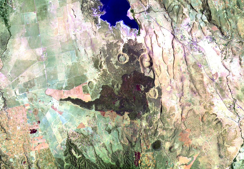 Prominent dark lava flows (center) erupted from vents in the Elmenteita Badlands, located between Lake Elmenteita (top) and Eburru volcano, the flanks of which appear at the bottom of this Landsat image. Cones and lava flows of varying ages are visible, some of which post-date the 10,000-year-old high-stand of Lake Elmenteita and are of Holocene age. NASA Landsat image, 1999 (courtesy of Hawaii Synergy Project, Univ. of Hawaii Institute of Geophysics & Planetology).