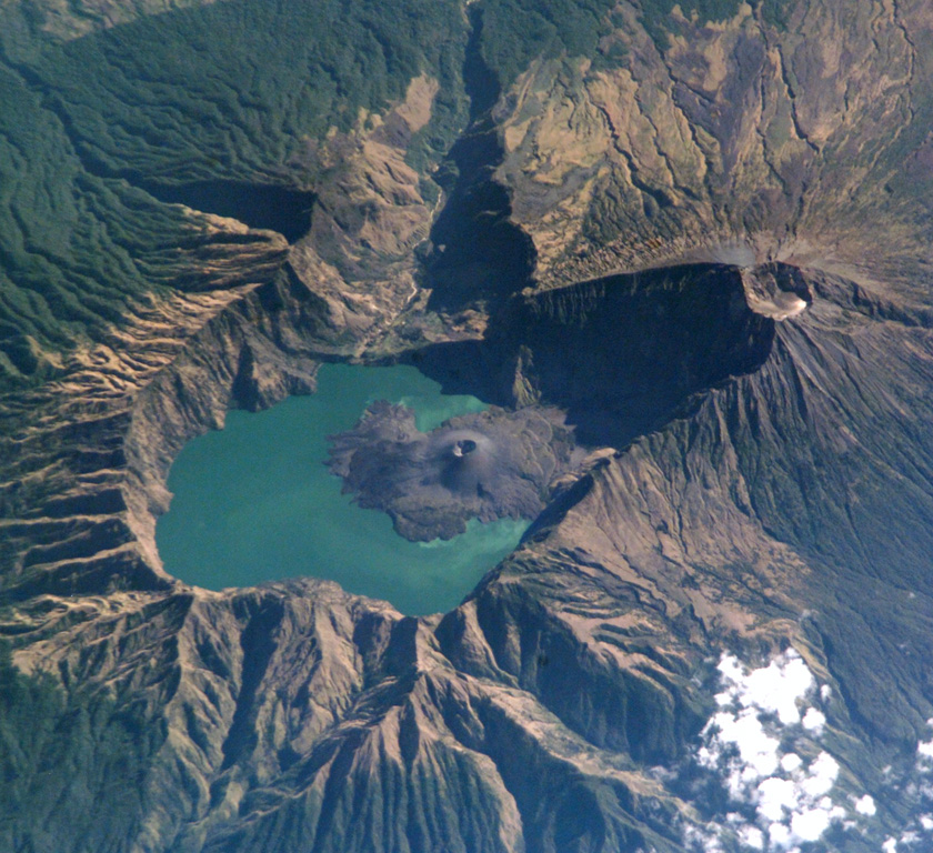 This International Space Station image from 2002 with N to the top shows the 6 x 8.5 km Segara Anak caldera. The Barujari cone in the center has produced lava flows that have entered the lake. The summit of Rinjani (right) contains a crater that postdates caldera formation. NASA International Space Station image ISS005-E-15296, 2002 (http://eol.jsc.nasa.gov/).
