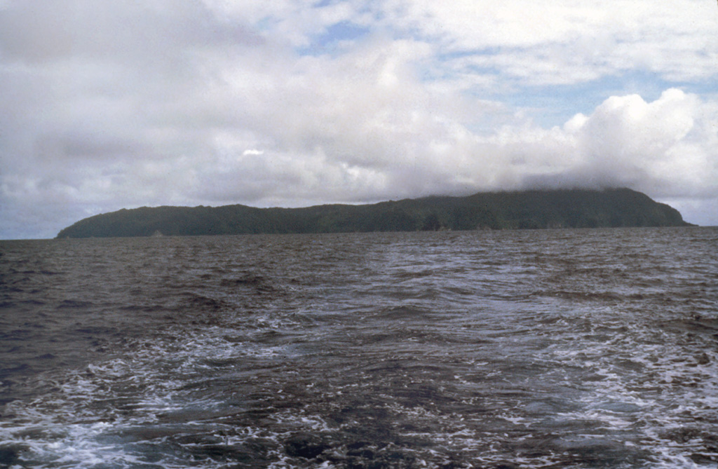 The low profile of Isla del Coco is seen from the NE, taken from the R/V Searcher of the University of Costa Rica.  The 22 km2 rain-drenched island was discovered by the Spanish pilot Juan Cabezas around 1526 CE, and the Costa Rican flag was first planted on the island in 1869.  Isla del Coco is the only subaerial portion of the Cocos Ridge, which extends from the Galápagos hot spot to the Mesoamerican trench.  Construction of a Pliocene-Pleistocene shield volcano was followed by caldera formation and the emplacement of a trachytic lava dome. Photo by Pat Castillo, 1984 (Scripps Institution of Oceanography, University of California San Diego).