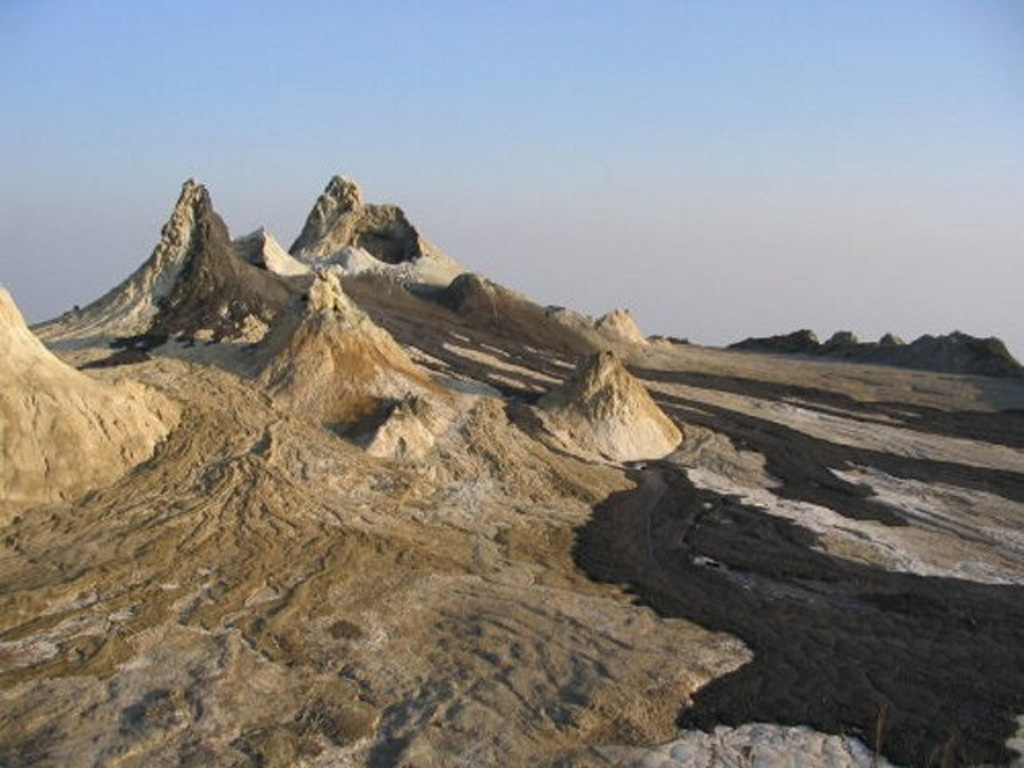 These fresh, dark-colored lava flows in the summit crater of Ol Doinyo Lengai volcano in Tanzania were erupted on 21 July 2004 from the spatter cone (about 12 m high) at the upper left, as well as other vents. The chemistry of these carbonatite lava flows causes rapid alteration of the flows, which can give them a light-colored surface within a few days of eruption. Frequent eruptions of small-volume lava flows in the summit crater began in 1983 and gradually filled the previously deep crater. Photo by Frederick Belton, 2004 (Tennessee State University).