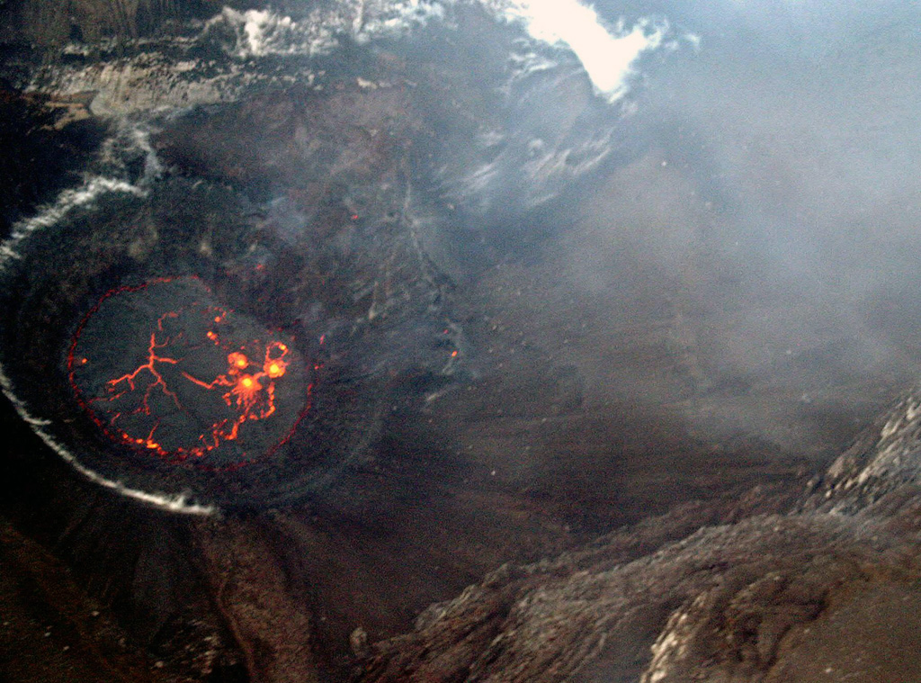 On 18 April 2005 a lava lake formed in the Chahalé crater, previously occupied by a crater lake. In this aerial photo, taken from the N on the morning of the 18th, considerable portions of the lava lake's surface still remained molten and incandescent. The lake's surface only remained molten only for a few hours, and by the next day its chilled surface emitted only gas plumes. Photo by Hamid Soulé, 2005 (Karthala Volcano Observatory).