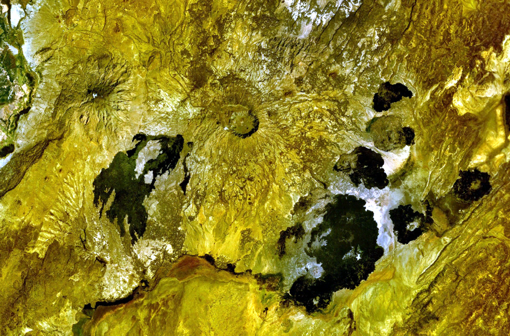 A caldera 4 x 5 km wide cuts the summit of Adwa volcano above the center of this NASA Landsat image with N to the top. This prominent volcano (also known as Aabida, Amoissa, or Dabita) is in the southern Afar area immediately E of Ayelu volcano, which lies above and to the left of the westernmost flank lava flow. These prominent young basaltic lava flows were erupted from vents on the W, E, and S flanks of Adwa volcano and overlap a sedimentary plain to the SE. NASA Landsat 7 image (worldwind.arc.nasa.gov)